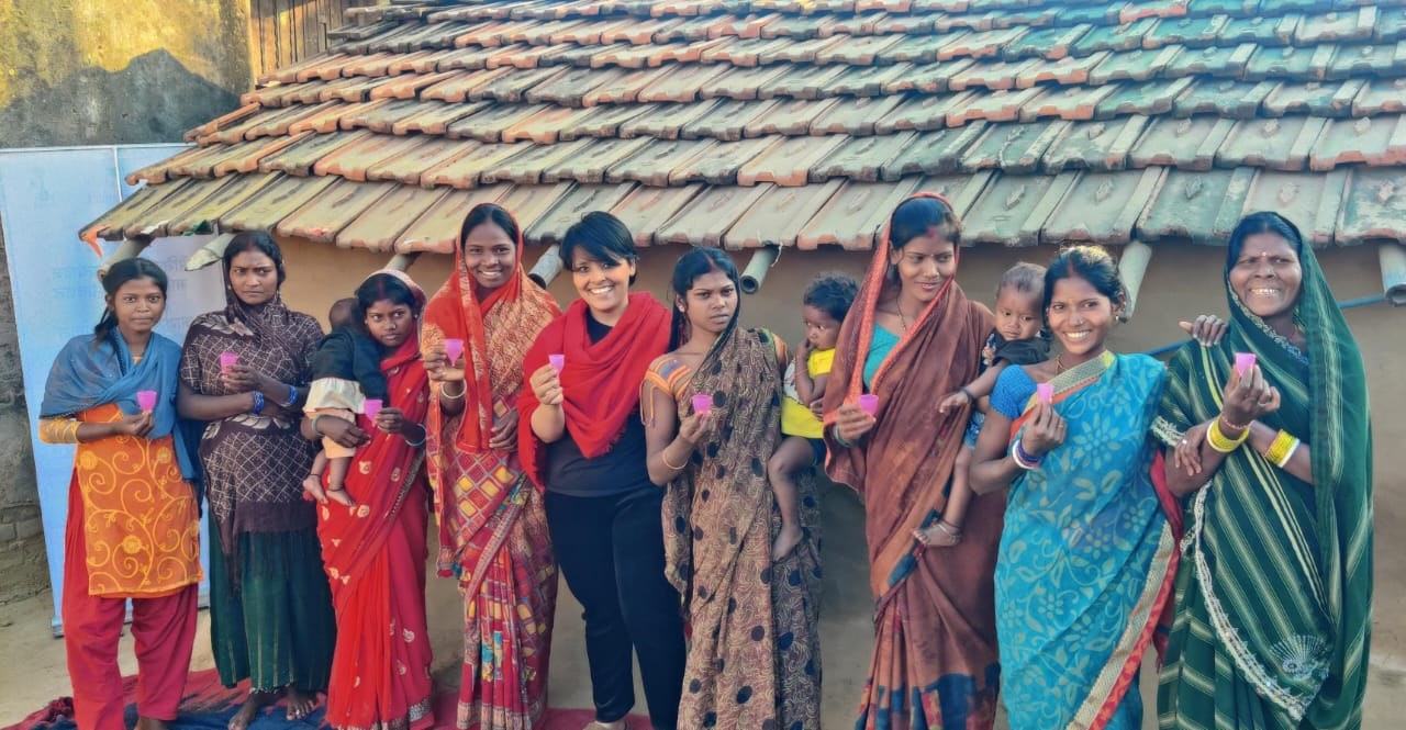 Women displaying menstrual cups during a village community gathering